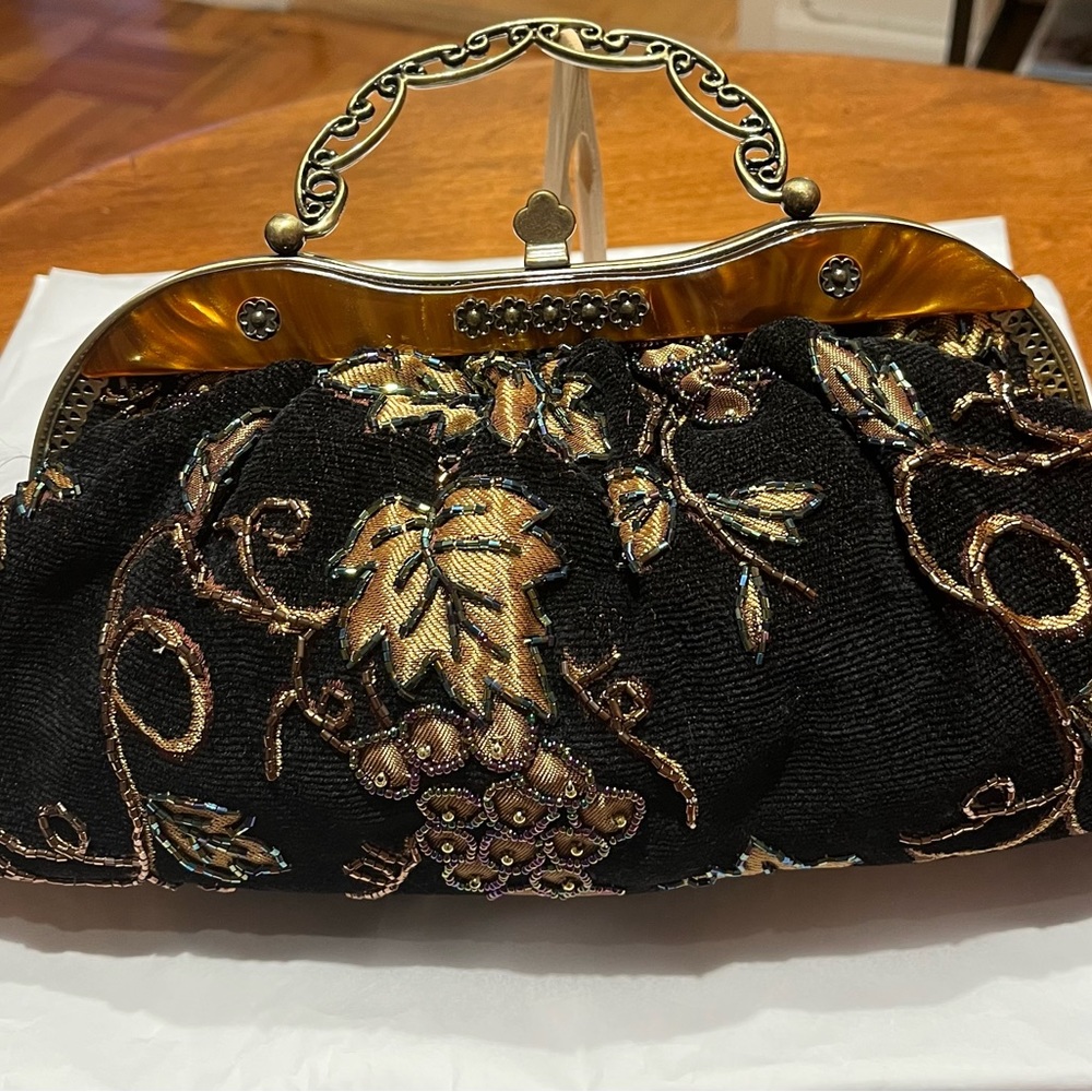 Beaded bag w/ gold metal handle and 24” gold metal removable shoulder strap.